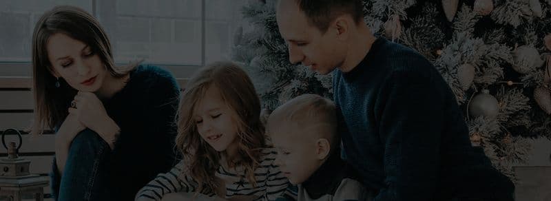Una familia orando junta con sus hijos pequeños
