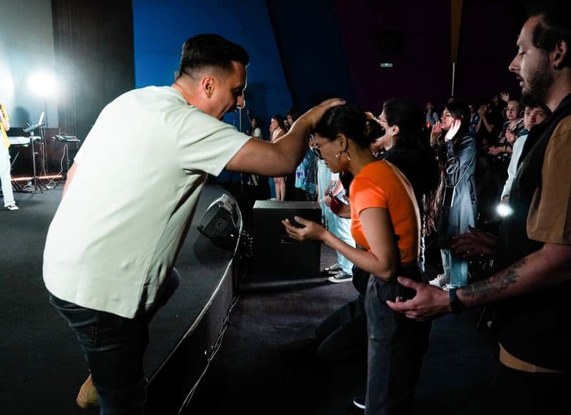 Miembros de la iglesia orando unos por otros al final de una reunión