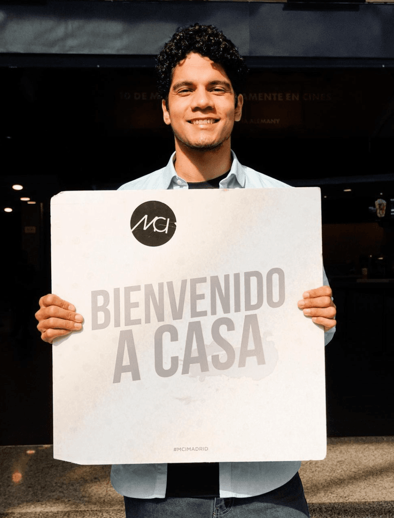 Un miembro de la iglesia sosteniendo un cartel que dice «Bienvenido a casa»